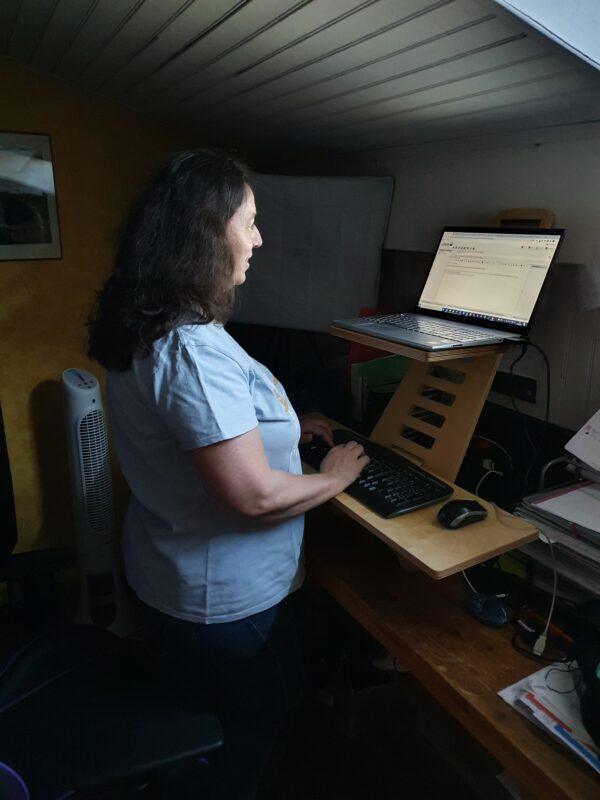 Nathalie Bagadey debout devant son ordinateur - Bureau Harmoni