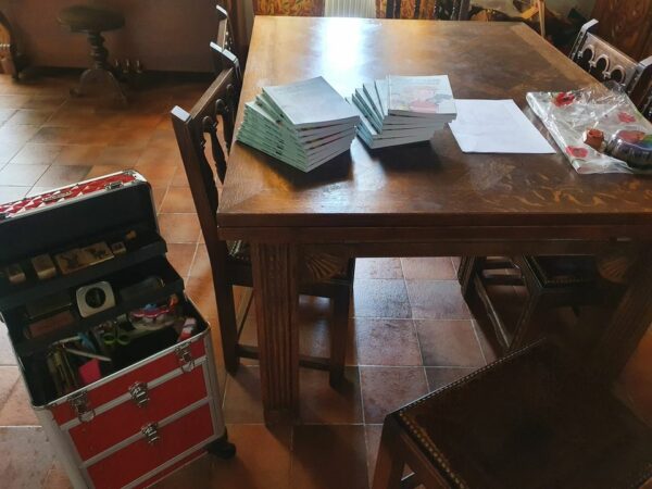 2 piles de livres à dédicacer sur la table de la salle à manger