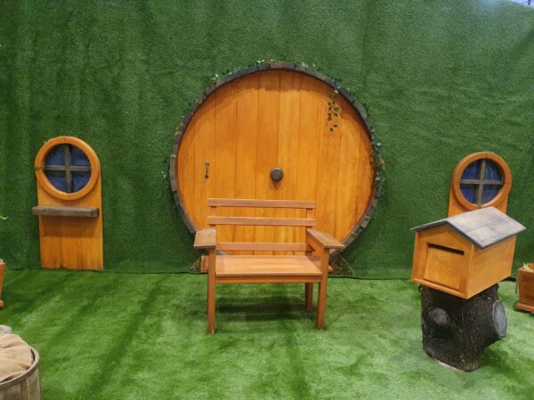 Décor devant lequel on peut se prendre en photo : porte ronde de maison de Hobbit avec siège et petits éléments de décor.