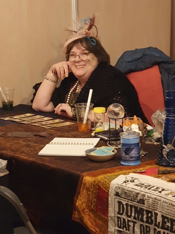 Photo de la diseuse de bonne aventure, avec ses cartes, son chapeau, sa décoration ésotérique...