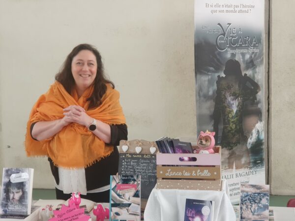 Nathalie Bagadey debout derrière son stand, avec châle.