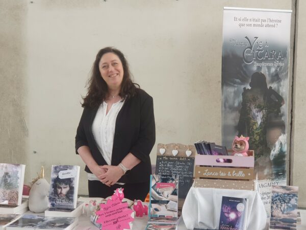 Nathalie Bagadey debout derrière son stand, sans châle.