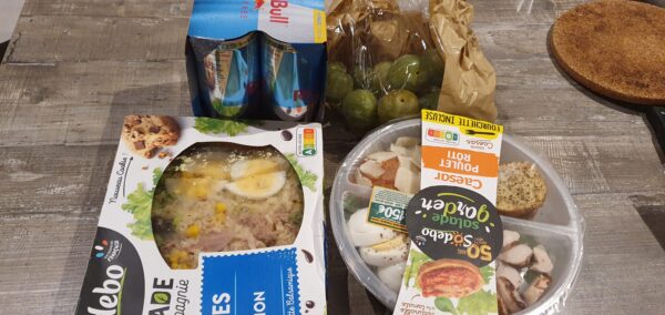 Photo des deux salades et prunes vertes choisies par Nathalie pour son premier salon + les cannettes de Red Bull en arrière-plan