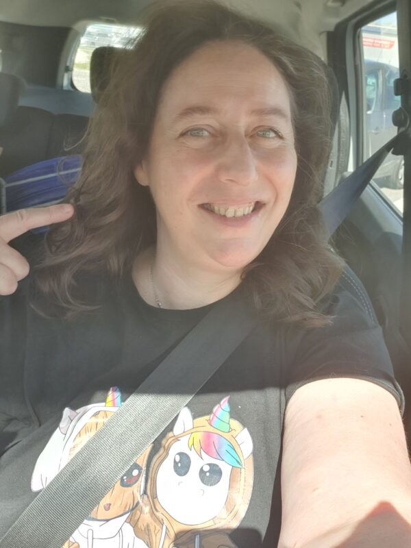 Photos de Nathalie bagadet au volant de sa voiture avant de prendre la route avec sa jolie coiffure.