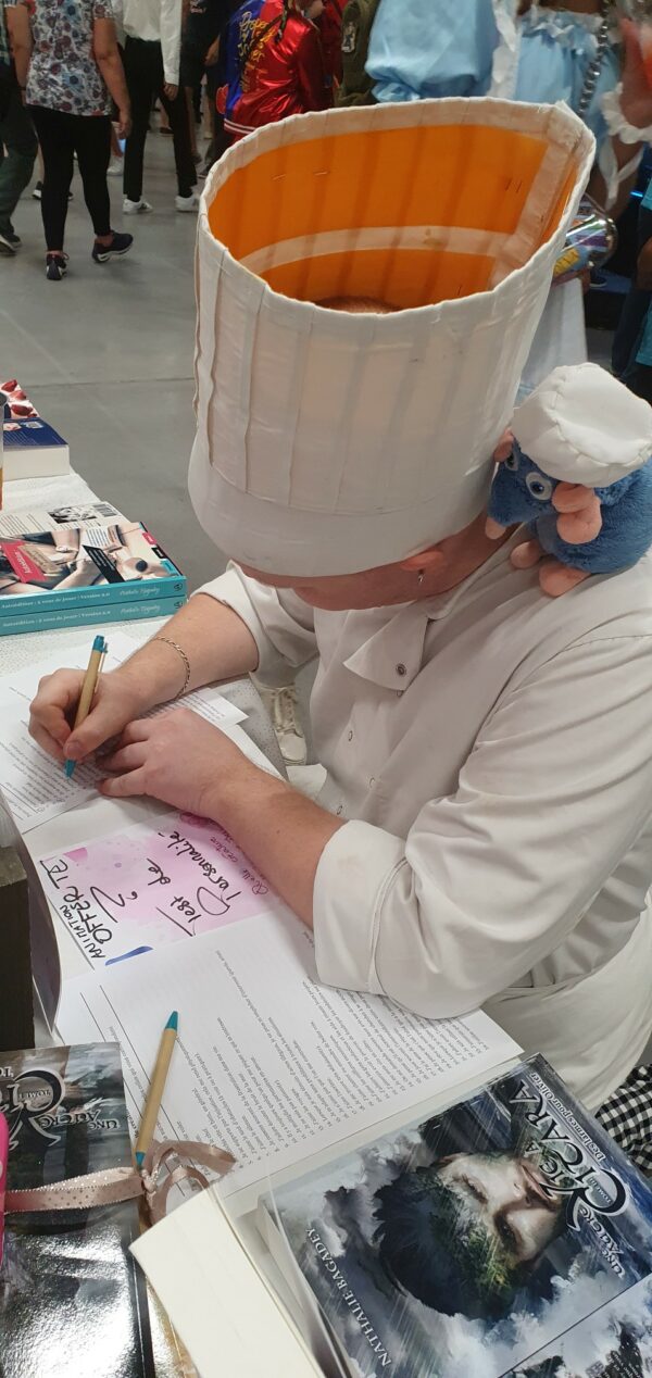 Mangalaxy - Un cosplayeur en tenue du cuisinier Alfredo (Ratatouille) en train de faire le test