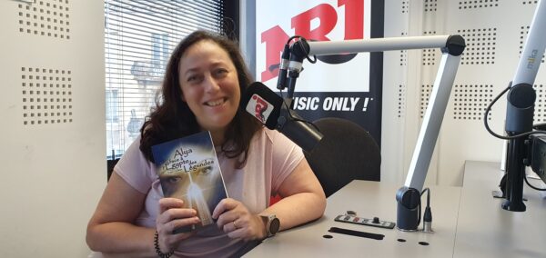 Nathalie Bagadey au micro d'NRJ le 10-10-24 avec son livre à la main 